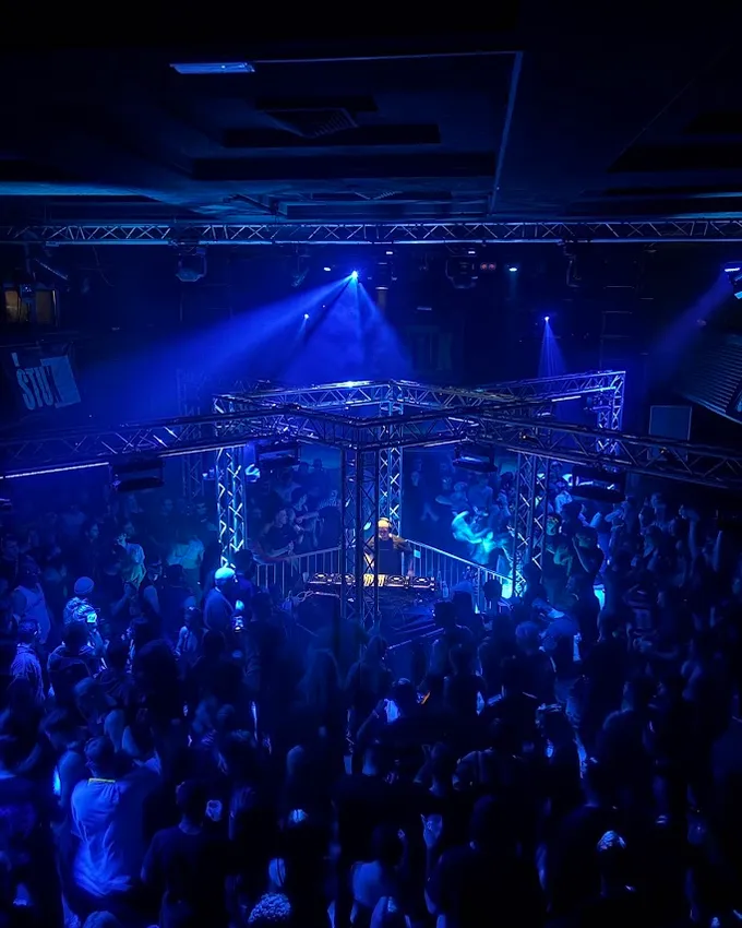 DJ pult sredi plesišča med tehno večerom HUSHHUSH na Štuku — polna dvorana v modri svetlobi